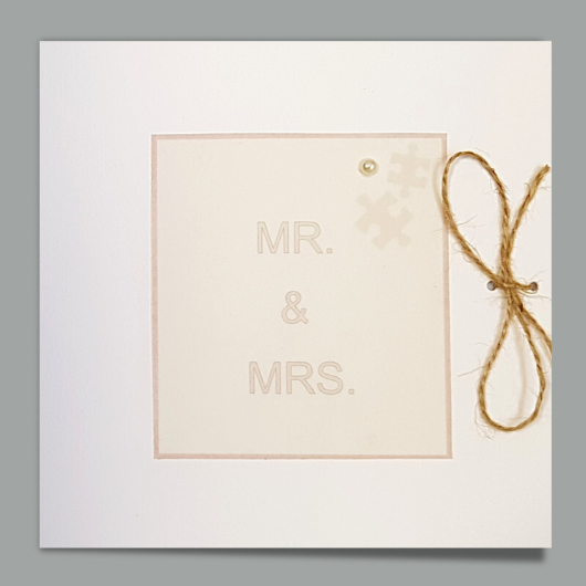 Bild der Karte «Mr. & Mrs. / Mrs. & Mrs. / Mr. & Mr.» mit Schnurschleife und Puzzleteilen
