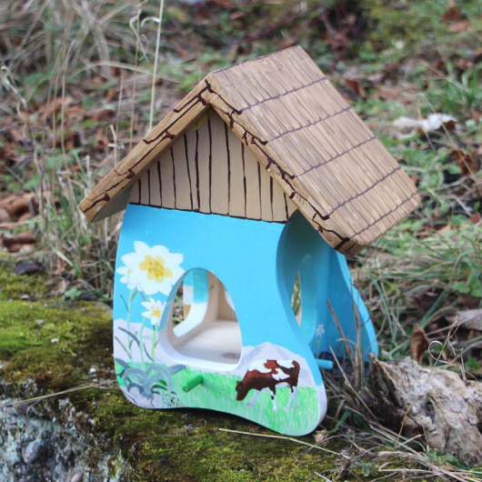 Bild der Futterstation Alpwiese mit grasender Kuh und Holzdach