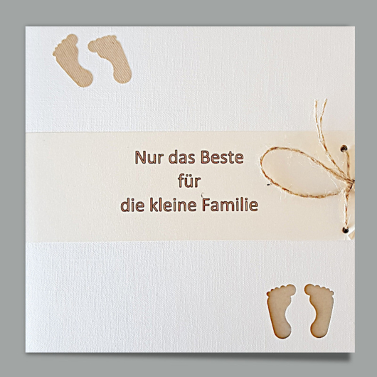 Bild der Glückwunschkarte «kleine Familie» mit Transparent-Streifen mit Spruch zwischen Fussabdrücken